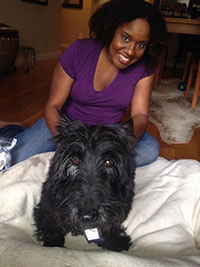 photo of Dr. Araba with a dog on the floor